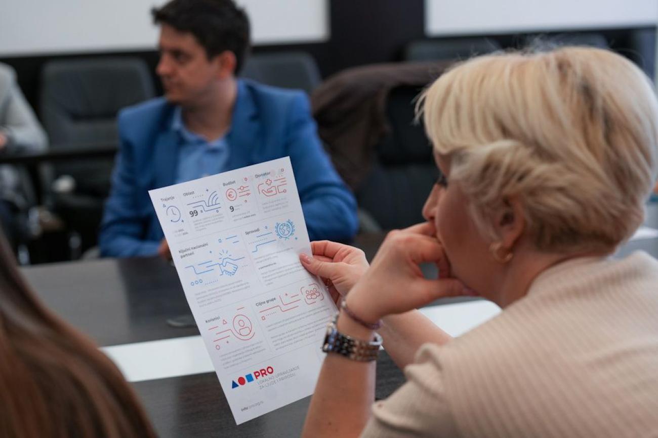 A woman is reading an infographic during a workshop. She is looking away from the camera