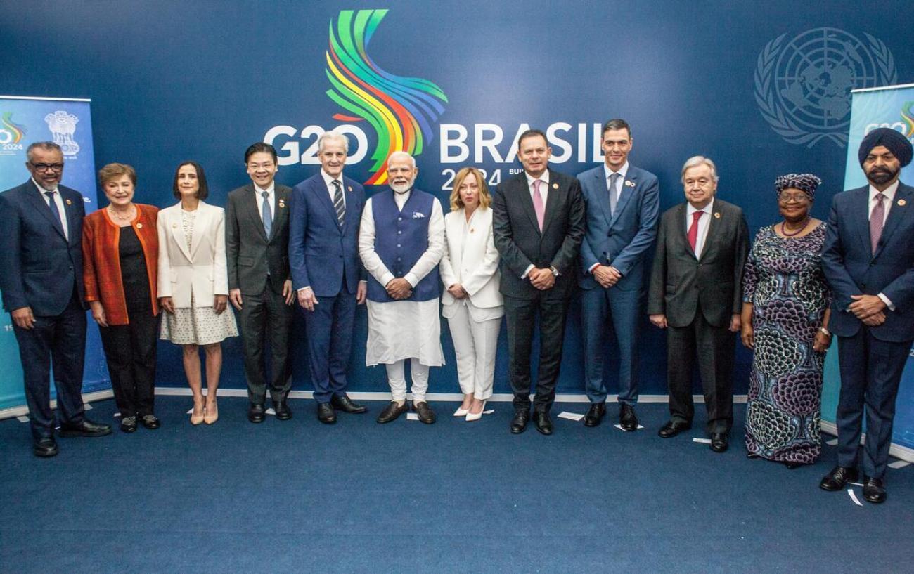 Secretary-General António Guterres with a group of G20 heads of sttae in front of a blue banner that says Brazil G20