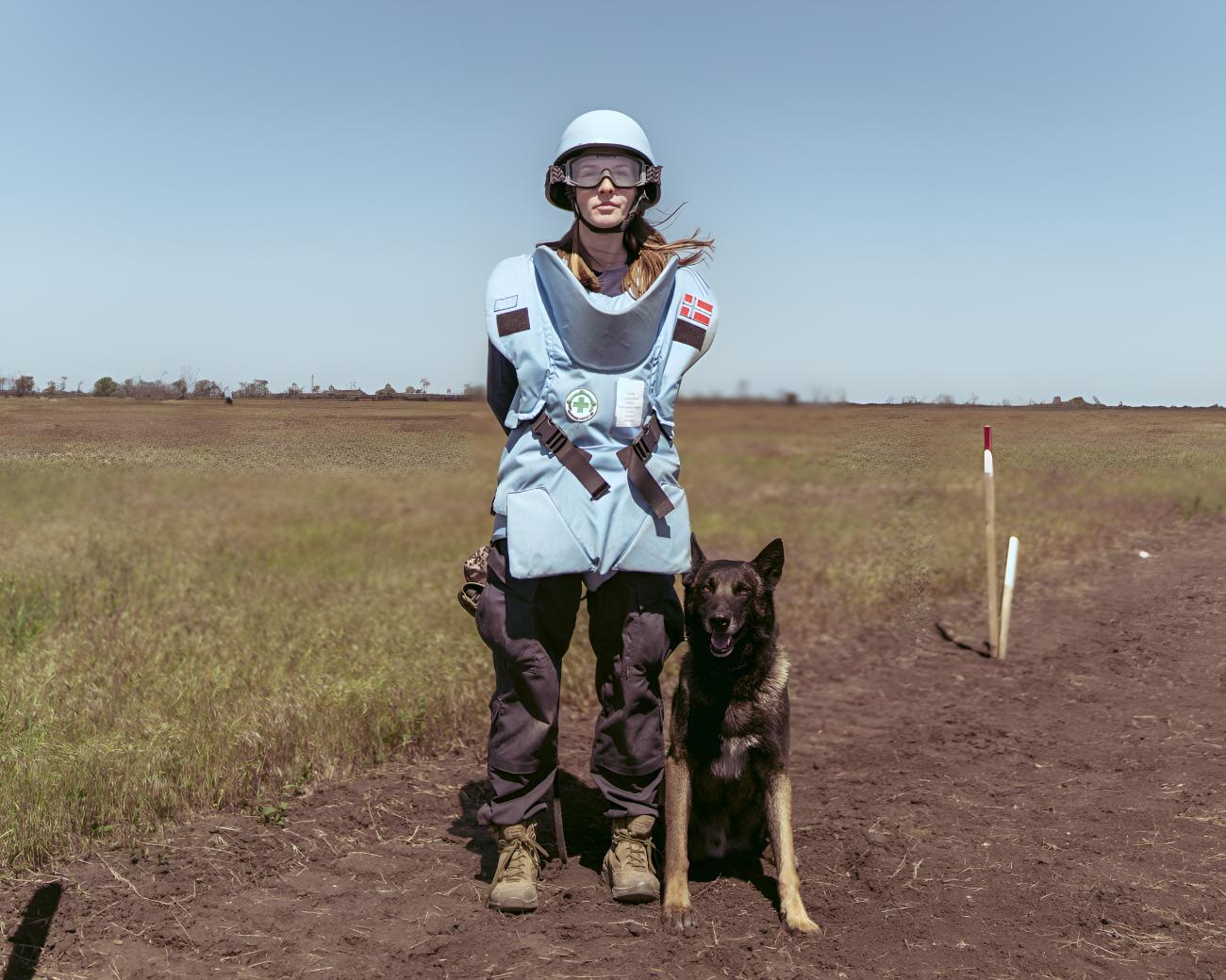 A deminer in Ukraine and her demining assistance dog.