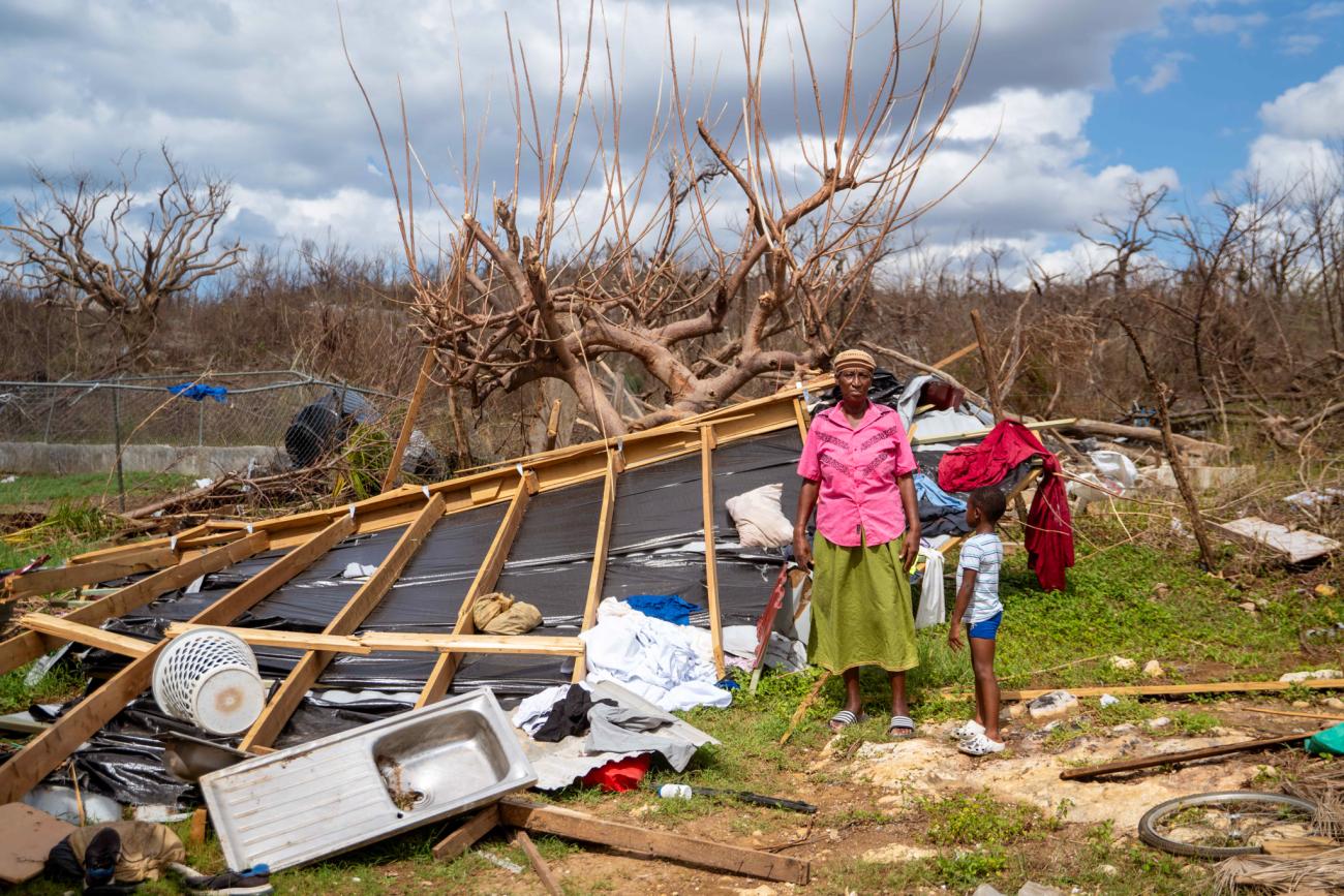 A woman and her son in Jamaica stand amidst the debris caused by a hurricane.