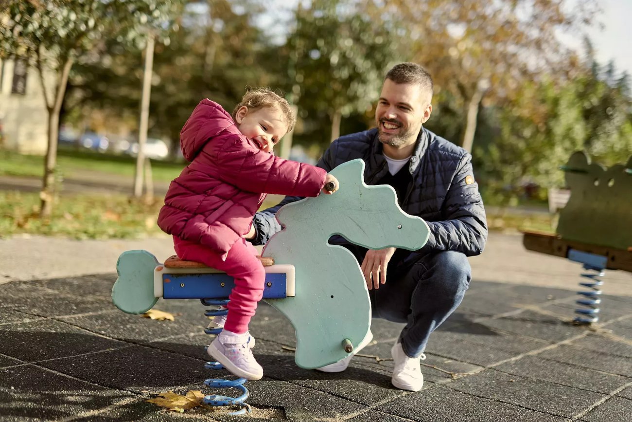 A father and his daughter at a playground in Montenegro.