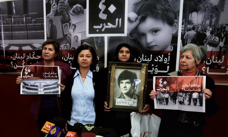 Four women in Lebanon hold photos of their missing relatives.