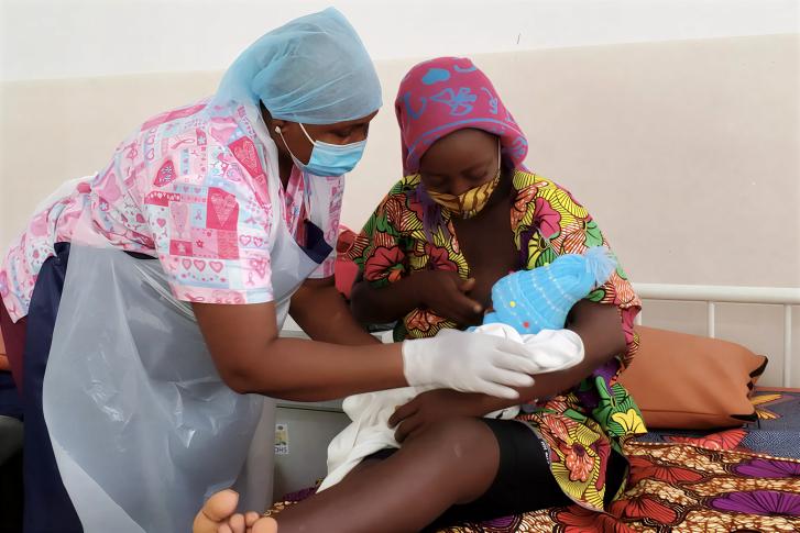 A nurse in Sierra Leone tends to a mother's baby.