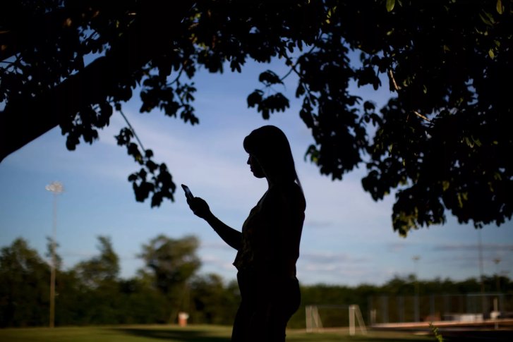 A woman looks at her phone.