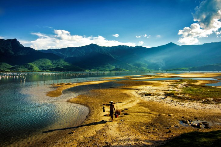 A wide shot of a man walking amid Viet Nam's stunning natural landscape.