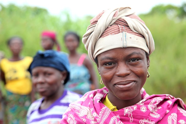 A woman in Benin stands in front of other women.