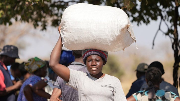 A woman in Namibia carries a bag on her head.