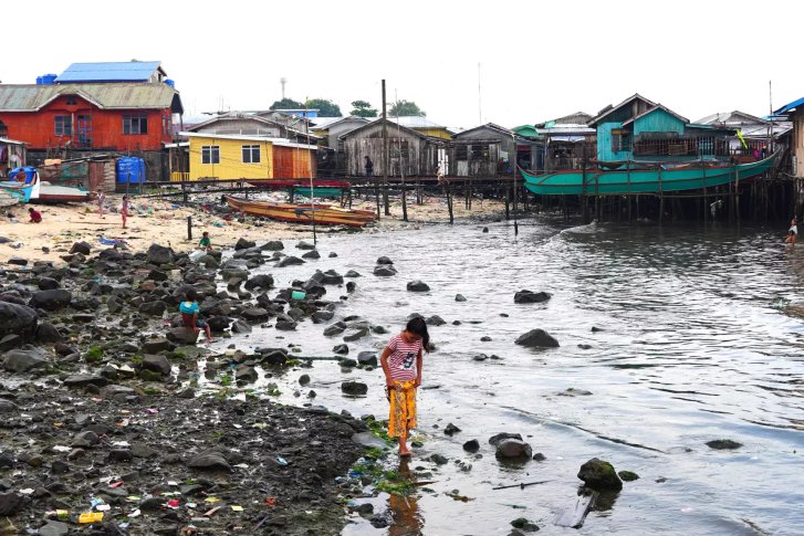 A girl in the Philippines walks near the coast.