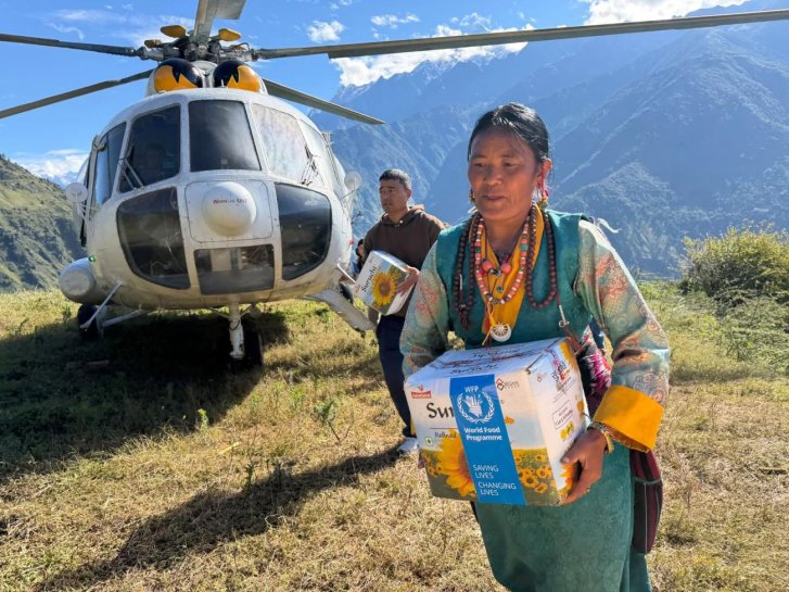 An aid workers delivers supplies after floods in Nepal.