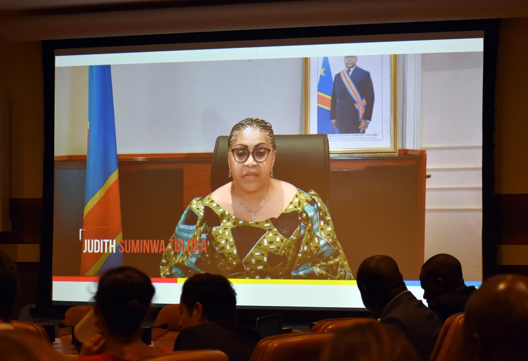 woman in yellow top speaks to meeting on screen 