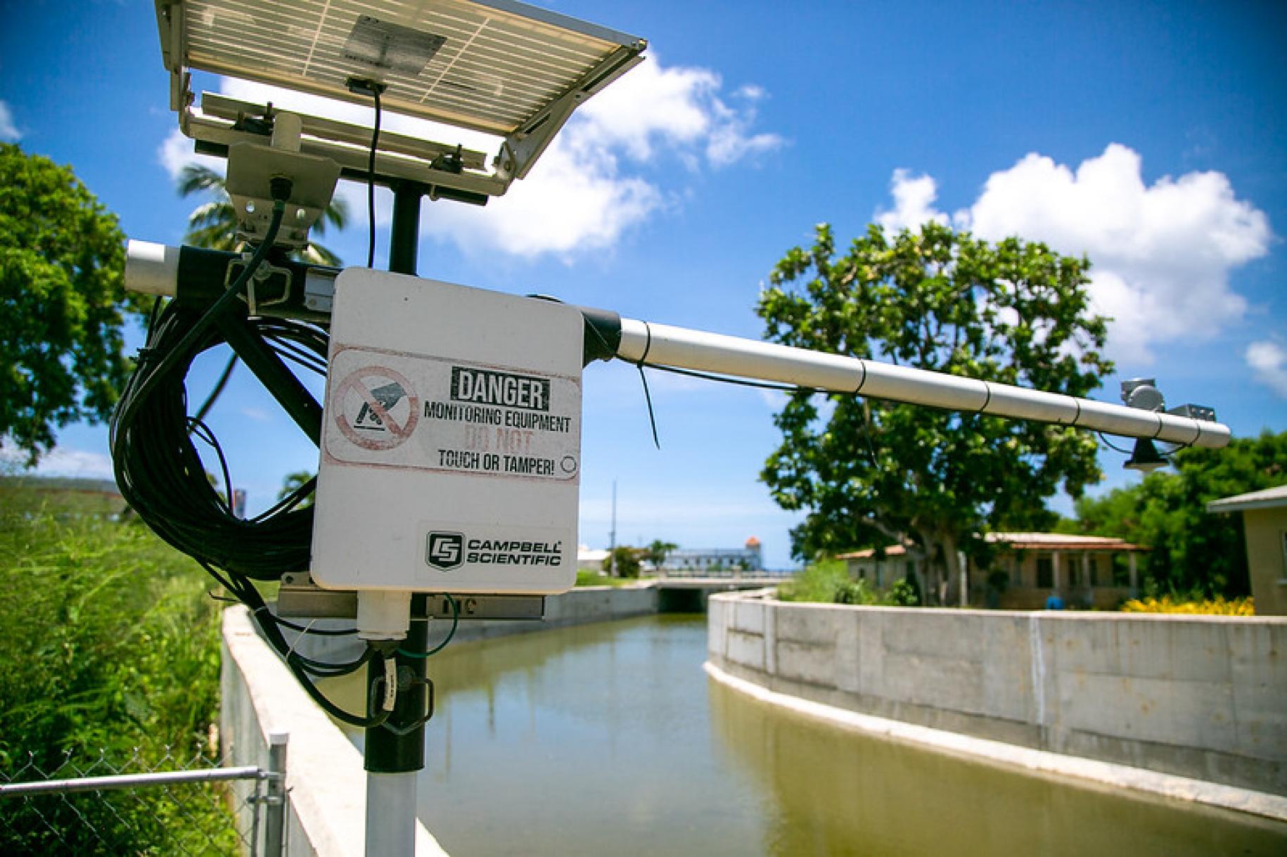warning sign by the side of a river 